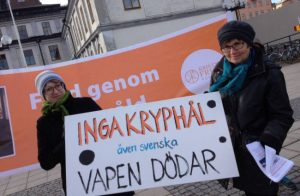 Manifestation av Kristna Fredsrörelsen med skylt "Inga kryphål - även svenska vapen dödar"